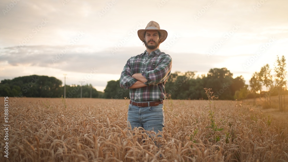 Cheerful and happy young man farmer in hat and plaid shirt smiling positively