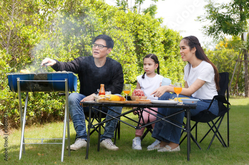 Asian family happy bright cute daughter Barbecuing in the courtyard