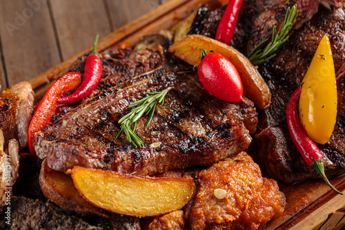 Closeup on assorted grilled meat set on wooden serving board