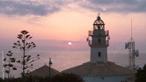 Time lapse, sunrise over the lighthouse, in Cullera, Valencia Spain. photo