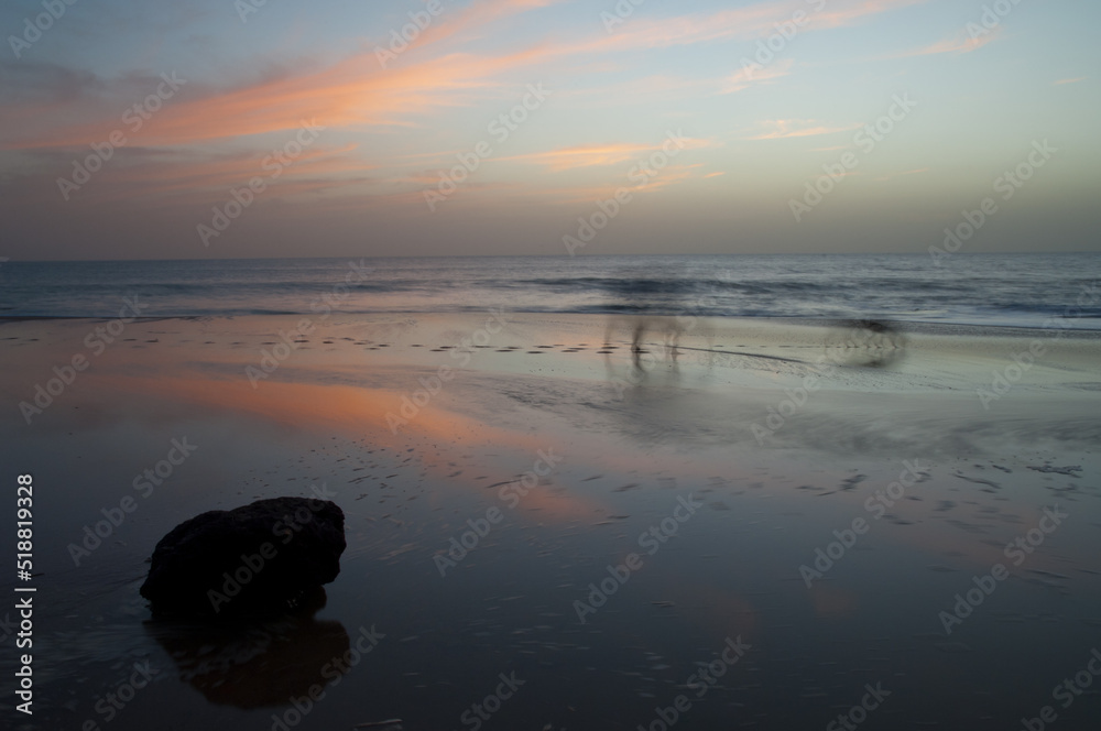 Person and dog walking on a beach at sunset. Natural Reserve of Popenguine. Thies. Senegal. Person and dog walking on a beach at sunset. Natural Reserve of Popenguine. Thies. Senegal.