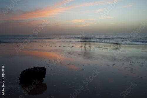 Person and dog walking on a beach at sunset. Natural Reserve of Popenguine. Thies. Senegal. photo