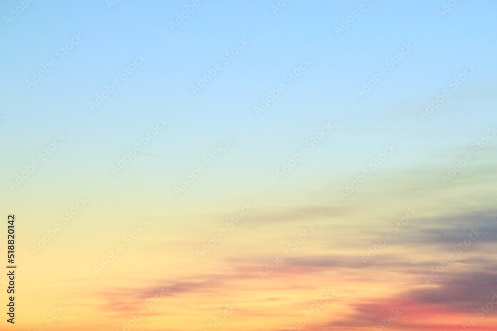 Paisaje creado por el cielo al atardecer. Nubes disipadas entre los colores azul, amarillo y rojo de la puesta de sol.