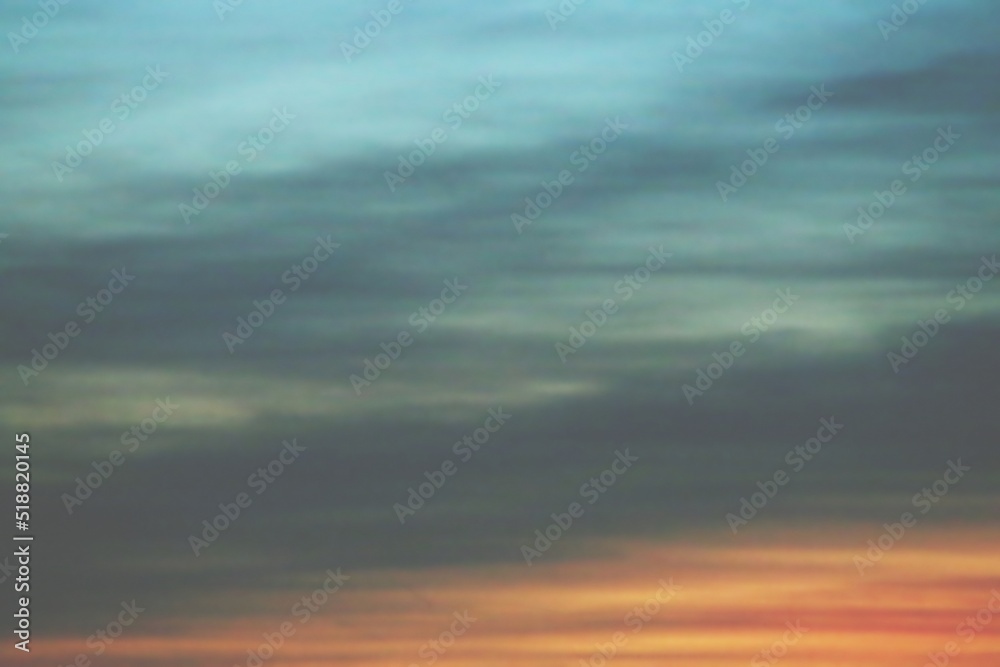 Paisaje creado por el cielo al atardecer. Nubes disipadas entre los colores azul, amarillo y rojo de la puesta de sol.