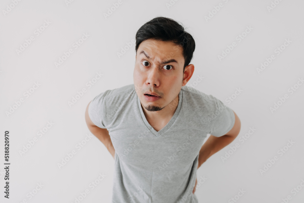 Funny obvious peeking Asian man in grey t-shirt isolated on white background. Funny obvious peeking Asian man in grey t-shirt isolated on white background.
