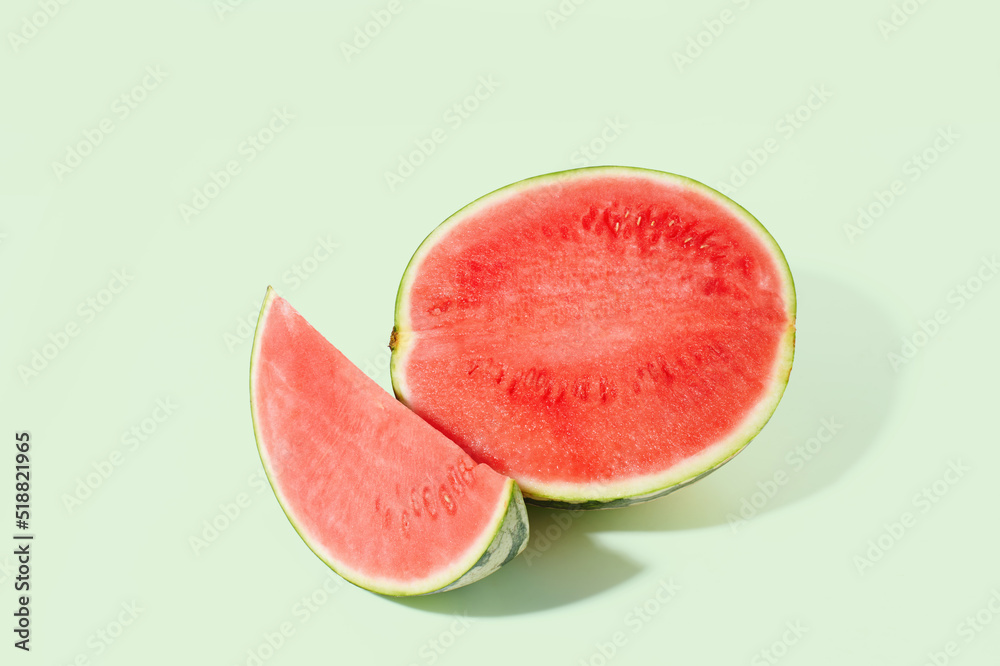 Cut watermelon on green pastel background
