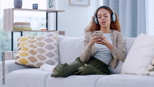 Wallpaper Mural Happy woman enjoying music by her favorite singer on a phone, using headphones. African American female listening to karaoke songs while sitting on a sofa. Smiling lady dancing to a beat or rhythm. Torontodigital.ca