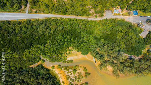 Aerial drone view of shoreline scenery and a narrow road in Pantai Marina Telaga Simpul, Kemaman, Terengganu, Malaysia.