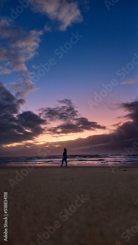 Landscape showing Woman silhouette in dramatic and colorful sunrise in the background at Jacaraipe Serra Espirito Santo beach © Marlon