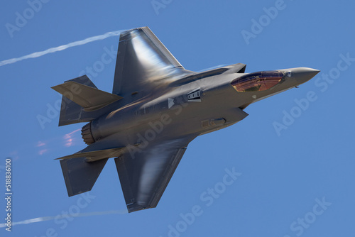 Very unusual close view of a F-35A Lightning II in a high G maneuver , with condensation clouds around the plane and afterburner on