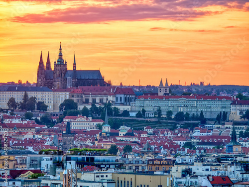  Beautiful aerial view with the Prague Castle at sunset and houses with red roof tiles.