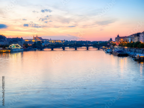 Prague, Czech Republic - June 2022: View with the Charles Bridge main touristic attraction at sunset. Medieval stone arch bridge over Vltava river in Prague