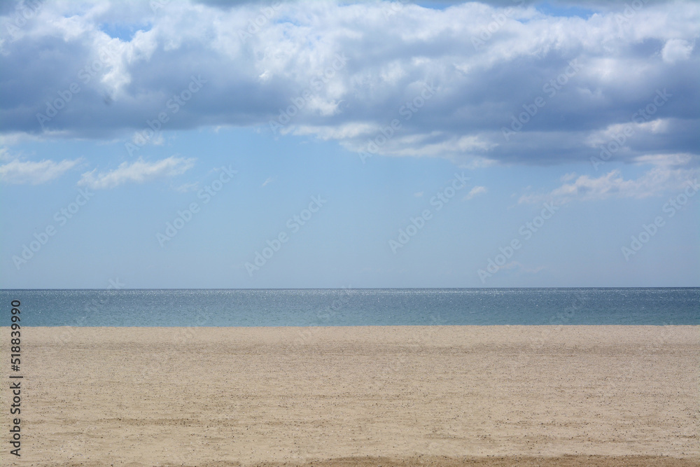Picturesque view of sandy beach near calm sea on cloudy day Picturesque view of sandy beach near calm sea on cloudy day