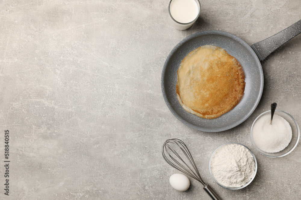 Frying pan with delicious crepe and ingredients on grey table, flat lay. Space for text Frying pan with delicious crepe and ingredients on grey table, flat lay. Space for text