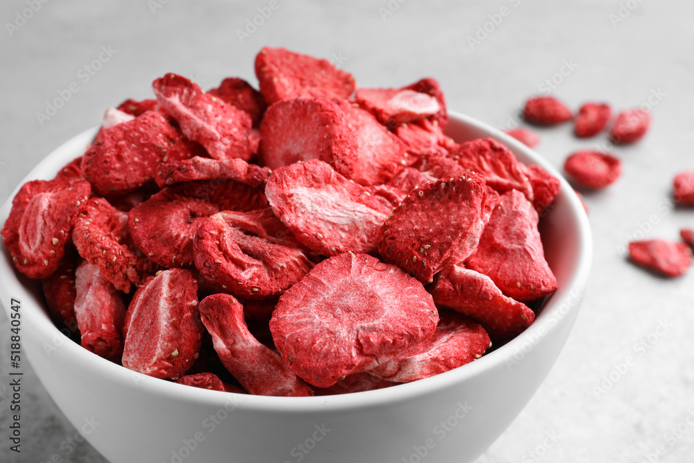 Bowl with dried strawberries on light grey table, closeup Bowl with dried strawberries on light grey table, closeup