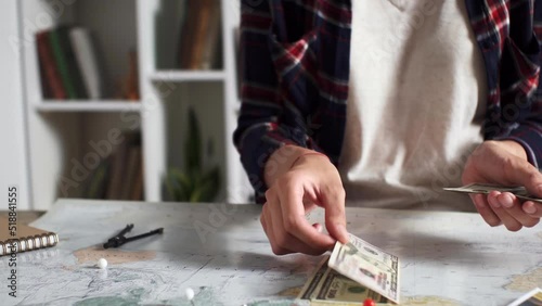 A tourist counts cash banknotes, money set aside for a trip, Preparing travel for a vacation in summer, Air travel in summer preparing a tourist route, collecting money for a trip
