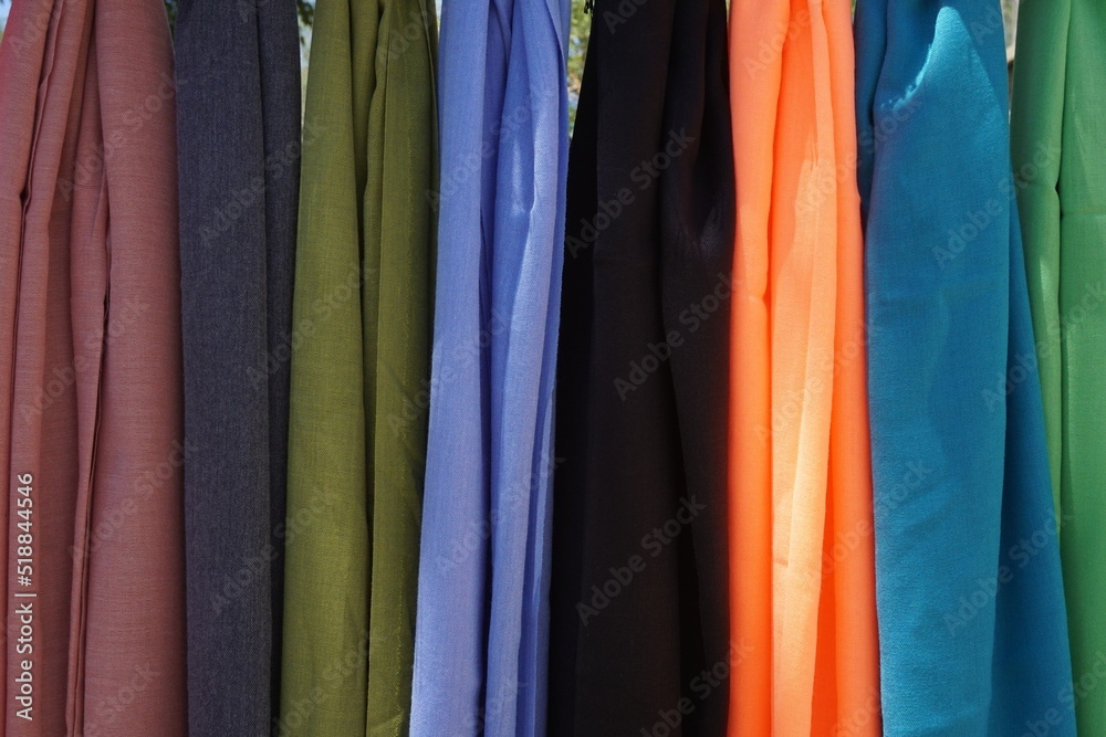 shawls lined up in different colors without patterns