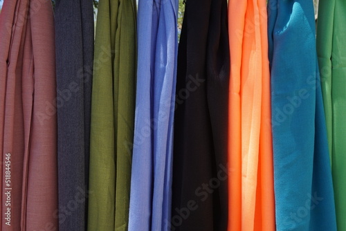 shawls lined up in different colors without patterns