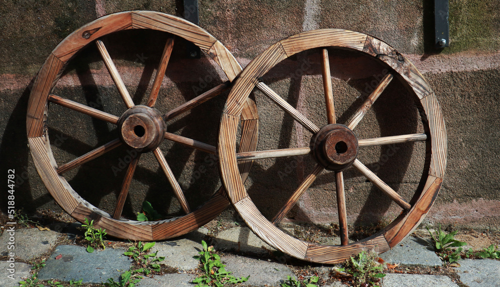 Old rustic wooden wheels on wall background Old rustic wooden wheels on wall background