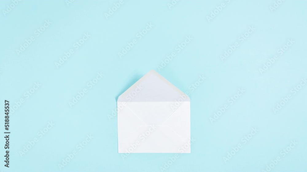 4k White paper airplane turns into an envelope that opens. Concept of delivering mail, letters and messages. Blue background. Stop motion animation. Flat lay. Copy space.