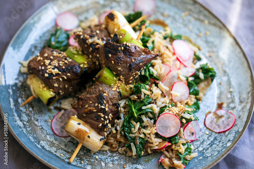 Beef steak  skewers with rice, kale and radishes
