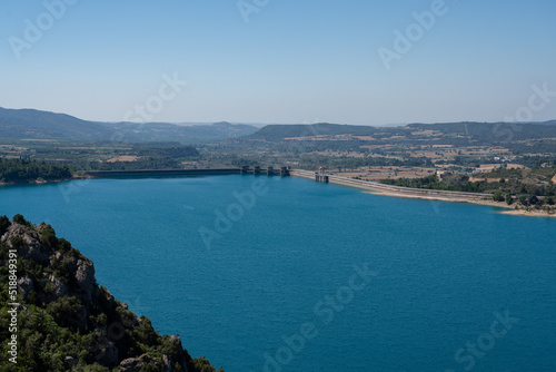 Large blue reservoir and distant hydro-electric dam