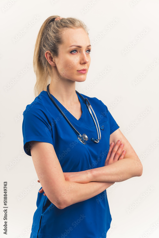 Modern heroes concept. Medical healthcare caucasian female worker in dark blue uniform and stethoscope with crossed arms, standing with a confidence on her face. Vertical studio isolated shot copy