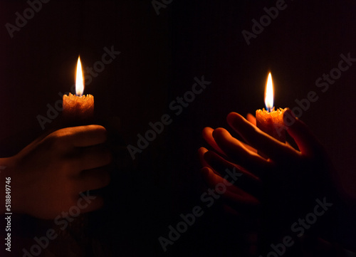 Foto burning candle in his hand, a prayer in the church