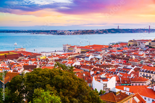 Fototapeta Naklejka Na Ścianę i Meble -  Beautiful panorama of old town Baixa district and Tagus River in Lisbon city during sunset, seen from Sao Jorge Castle hill, Portugal