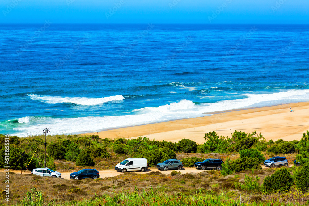 Nazare, Portugal: View of North beach and Atlantic Ocean with cars parked oposite sandy dunes