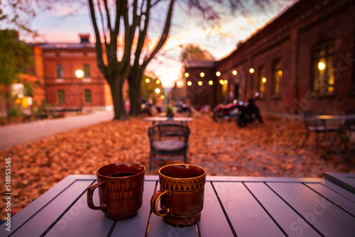 Lodz, Poland: A cup of hot drink on the table in the Ksiezy Mlyn historic distric during autumn evening photo
