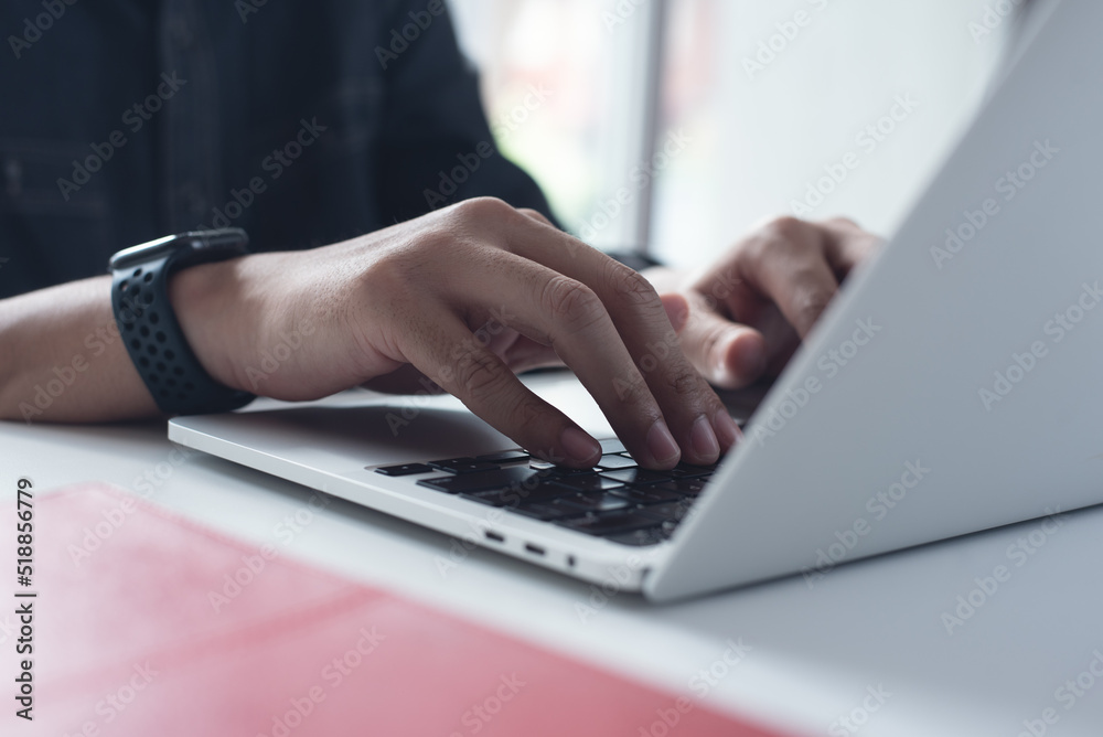 Business man working on laptop computer at home office, male hands typing on notebook keyboard, telecommuting, online job, working at home, portable office concept Business man working on laptop computer at home office, male hands typing on notebook keyboard, telecommuting, online job, working at home, portable office concept