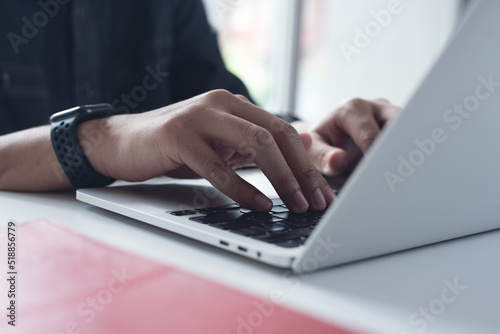 Business man working on laptop computer at home office, male hands typing on notebook keyboard, telecommuting, online job, working at home, portable office concept