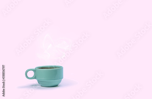 Green coffee cup on pink background.