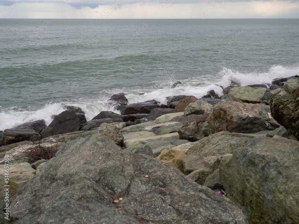 Rocky seashore. The shore is fortified with huge stones. Large waves on the pier.   Big wave. Windy weather