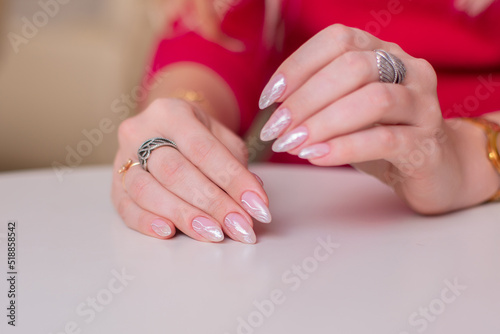 Female hands with wedding manicure nails, nude gel polish, on pink background 