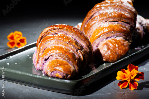 Fresh baked homemade Ube Croissants using flavouring and purple yam powder and three book folds, lightly sprinkled with coconut.