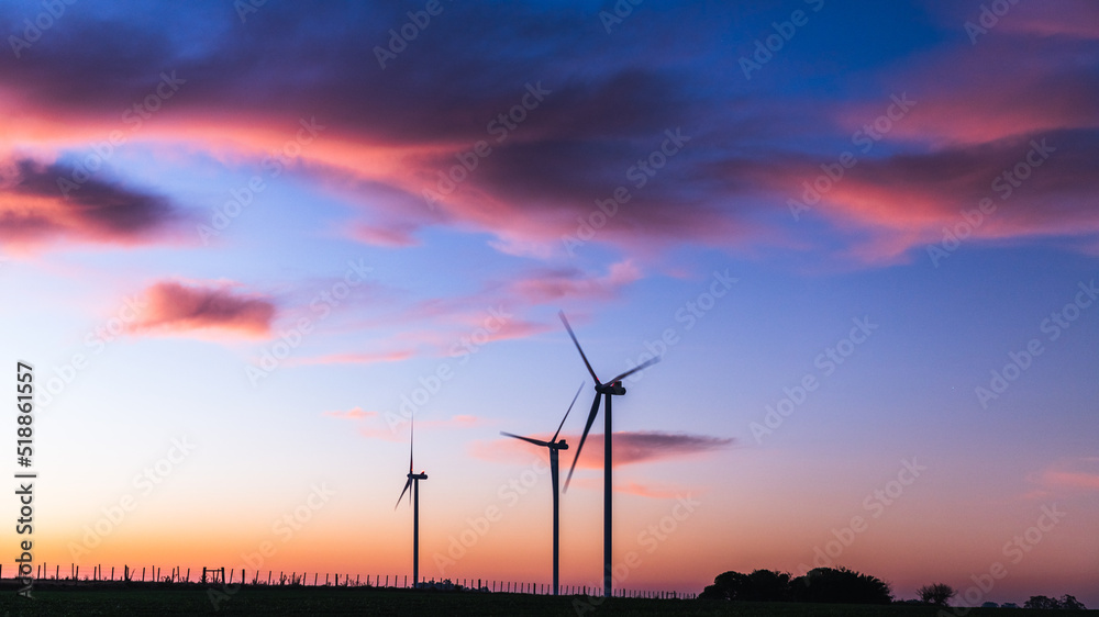 Obraz premium Silhouette of three modern windmills under a blueish sunset on the outskirts of Kiyú, San José, Uruguay