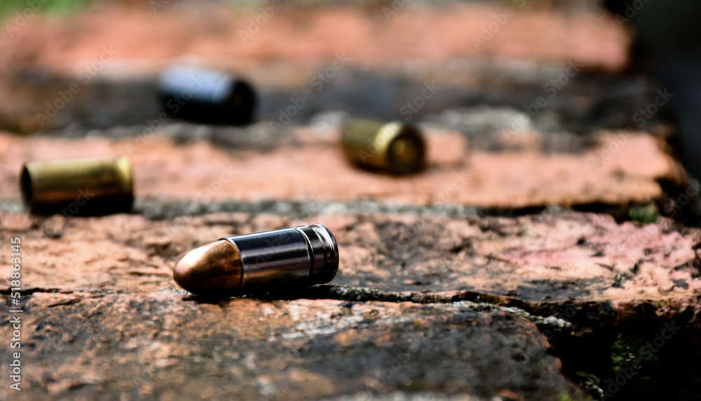 9mm pistol bullets and bullet shells on brick floor, soft and selective focus, concept for searching a key piece of evidence in a murder case at the scene.