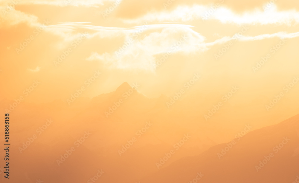 silueta de montañas con nubes anaranjadas del atardecer brillante, hora dorada en montañas	, cielo de atardecer amanecer 
