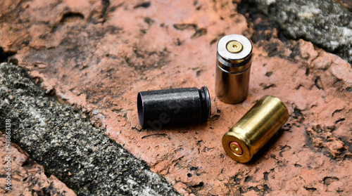 9mm pistol bullet shells on brick floor, soft and selective focus on black bullet shell, concept for searching a key piece of evidence in a murder case at the scene.