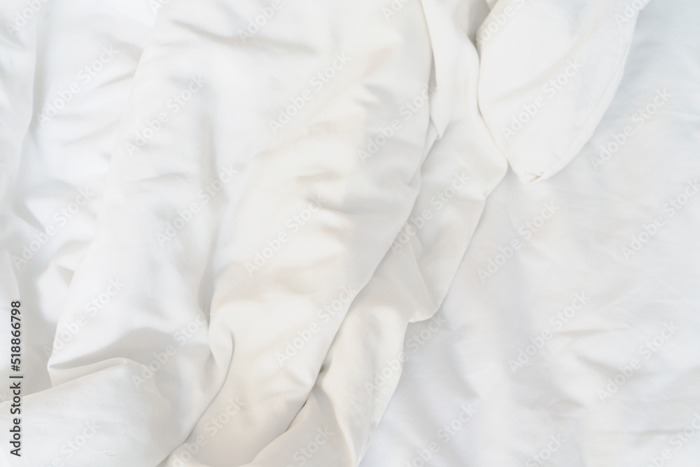 Obraz premium after waking up in theâ€‹ morning. The crinkle blanket on the bed in the hotel with the sunâ€‹lightâ€‹ onâ€‹ theâ€‹ blanket