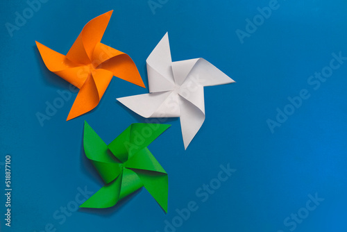 Indian tricolor paper pinwheels isolated on blue background. Conceptual image for Indian national day celebration and events. space for text.