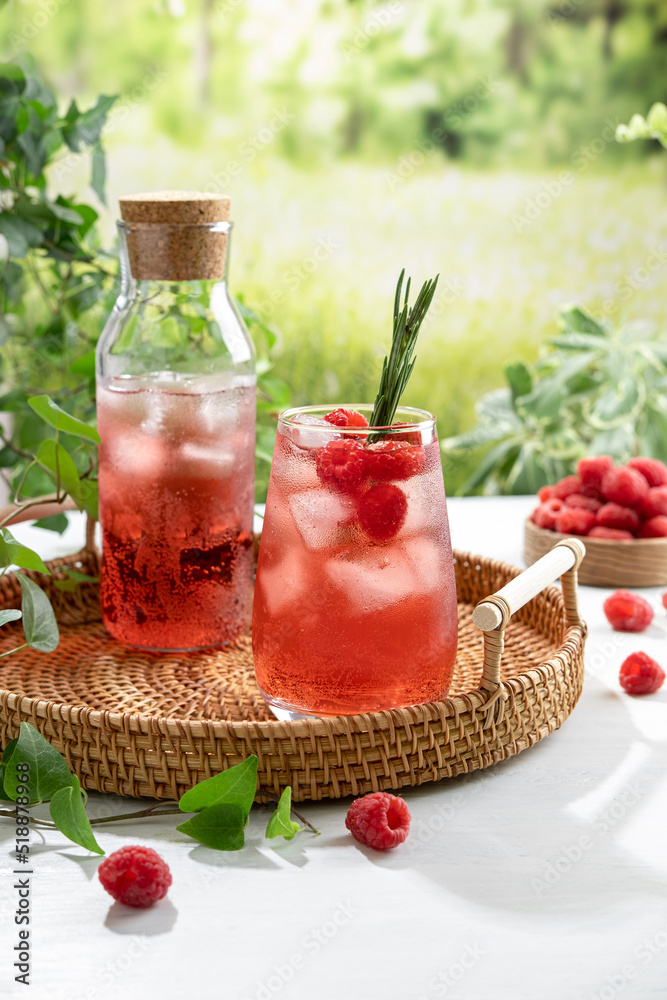 Summer refreshing non-alcoholic cocktails. Raspberry lemonade garnished with fresh rosemary. Summer raspberry beverage with sparkling water. Copy space. Summer refreshing non-alcoholic cocktails. Raspberry lemonade garnished with fresh rosemary. Summer raspberry beverage with sparkling water. Copy space.