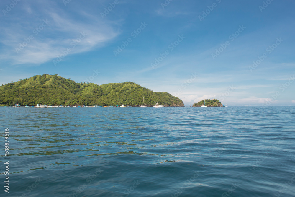 coastal landscape with green trees and boats on a sunny day in Guanacaste in Costa Rica
