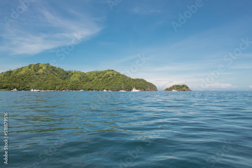 coastal landscape with green trees and boats on a sunny day in Guanacaste in Costa Rica