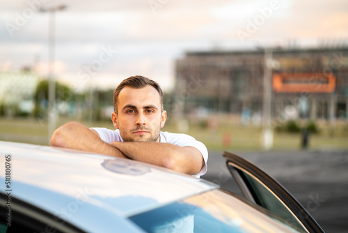 young man poses with his car, proud handsome driver