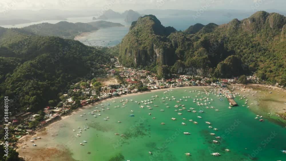 Aerial drone of cove with the blue lagoon and tourist boats. Famous tourist place town of El Nido on the island of Palawan. Seascape with blue bay and boats view from above. Summer and travel vacation