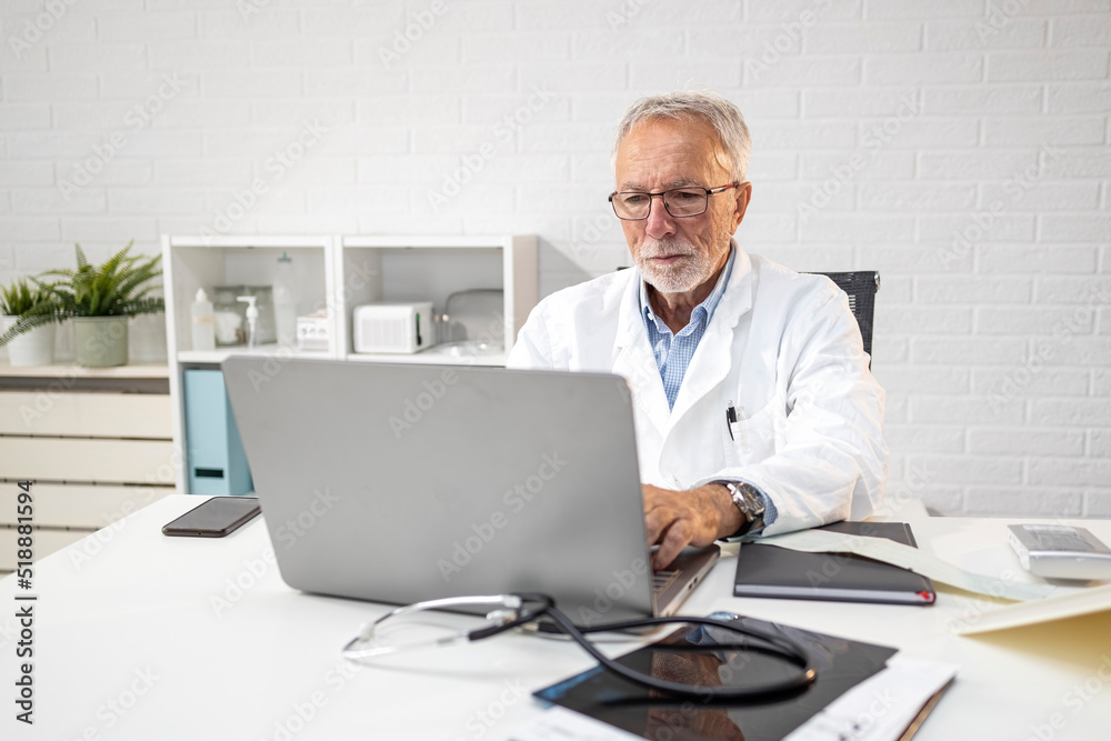 Experience doctor in ambulance sitting in front of his laptop and work Experience doctor in ambulance sitting in front of his laptop and work