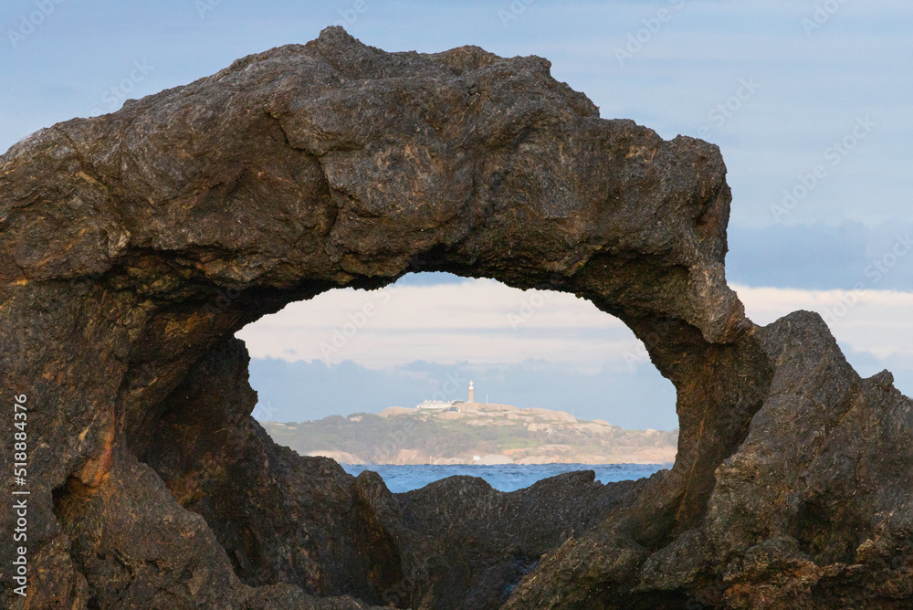 Rock arch framing Montague Island, Narooma, NSW, June 2022